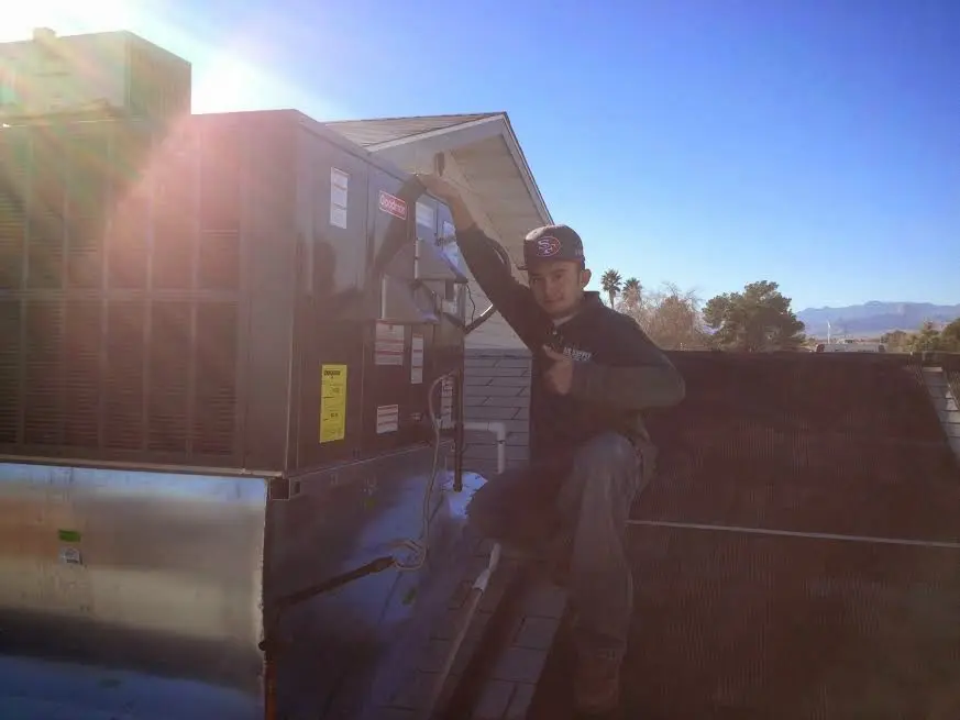 HVAC technician performing AC Tune-Up on a rooftop unit in West Manchester